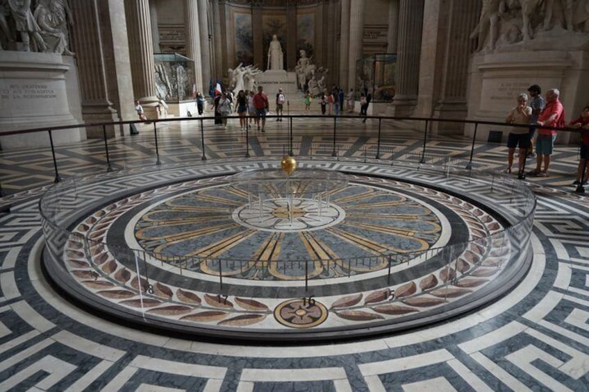 A circular mosaic floor with geometric patterns and a central emblem. 4
