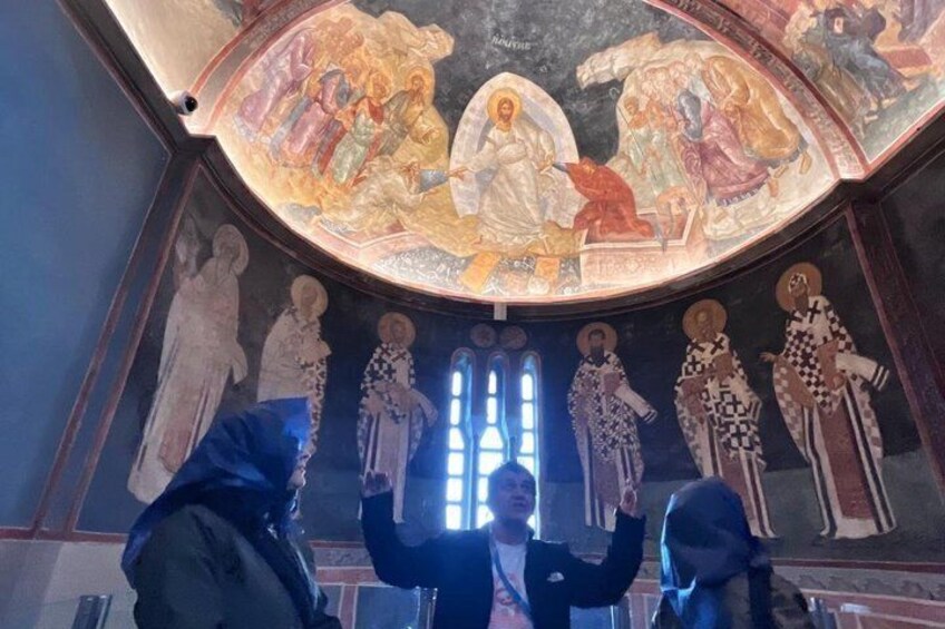 A church interior with a frescoed ceiling and religious figures. 1