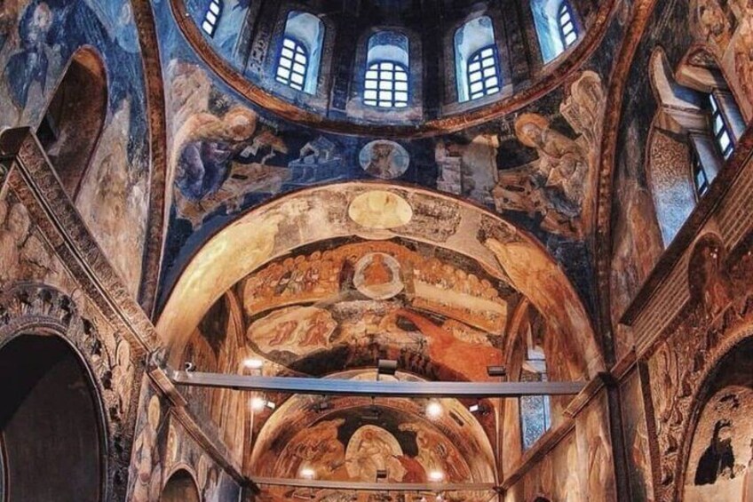 A historic building's interior with frescoes, arched ceilings, and a central dome. 2