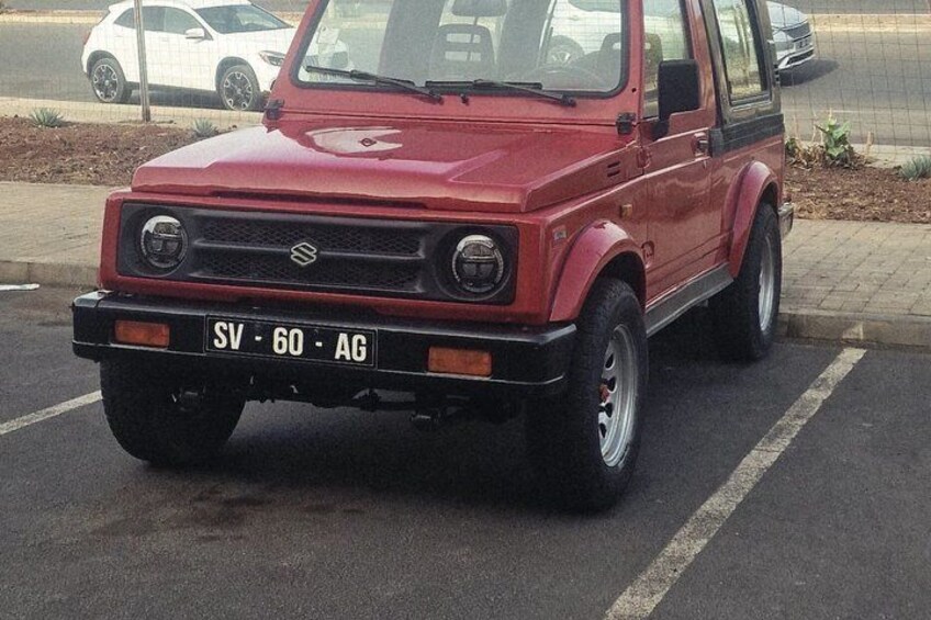A red Suzuki car parked in a lot with a visible license plate 'SV-60-AG'. 5