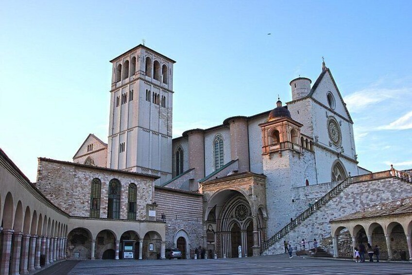 A historic church with a bell tower, arched windows, and a staircase leading to the entrance. 1