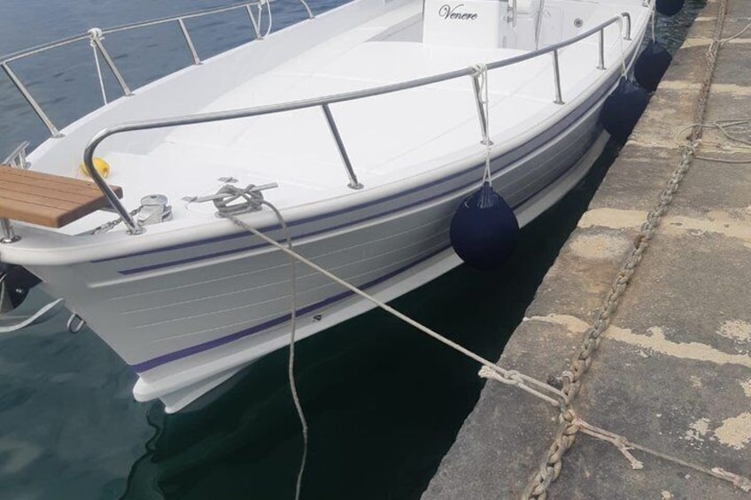 A white boat docked at a pier with a name 'Venere' on the side. 3