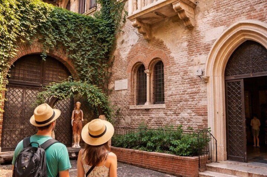 A historic building with arched windows and a statue in front. 5