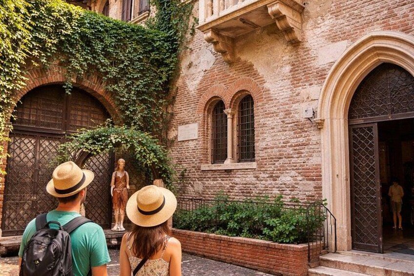 A historic building with arched windows and a statue in front. 4