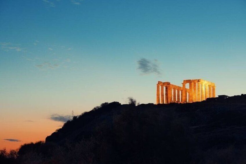 Ancient ruins illuminated at dusk, set against a clear sky. 3