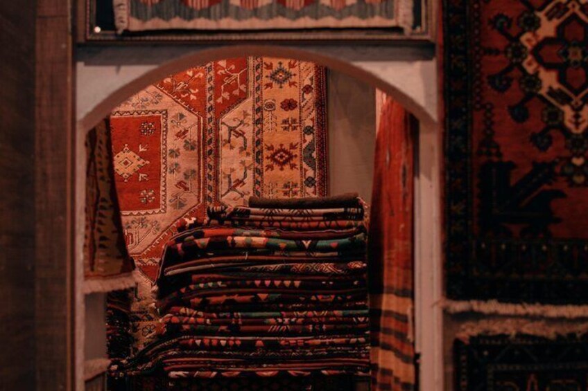 A stack of colorful rugs in an archway. 4