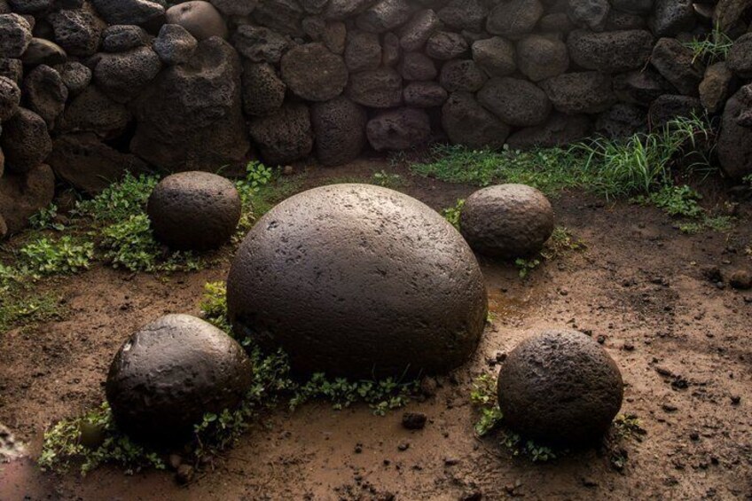 A stone wall with large boulders and sparse vegetation. 3