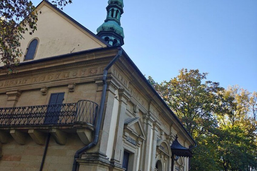 A historic building with a balcony, a clock tower, and a clear blue sky. 2
