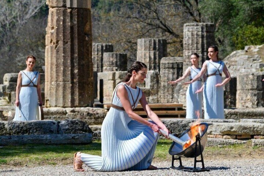 A person cooking outdoors near ancient ruins. 5