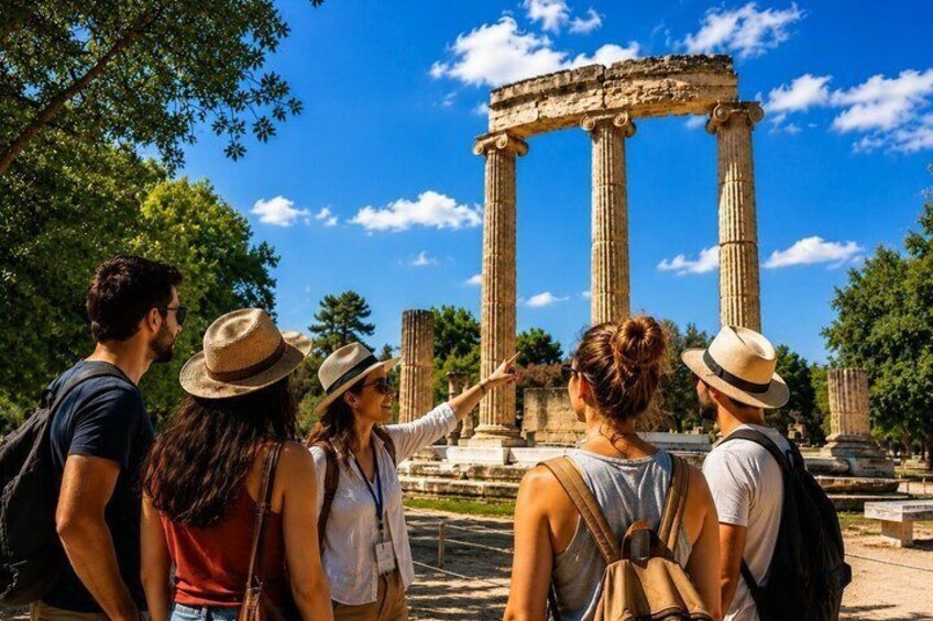A group of tourists observing ancient columns at a historical site. 1