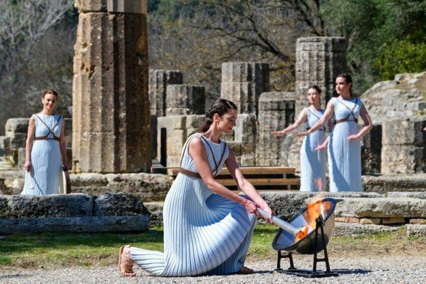 A person cooking outdoors near ancient ruins. 3