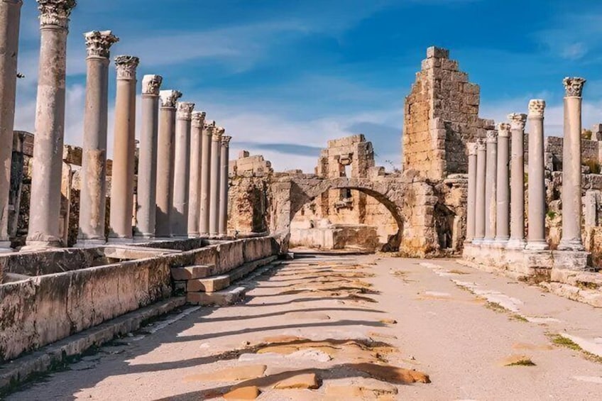 Ancient ruins with columns and an arched structure. 4