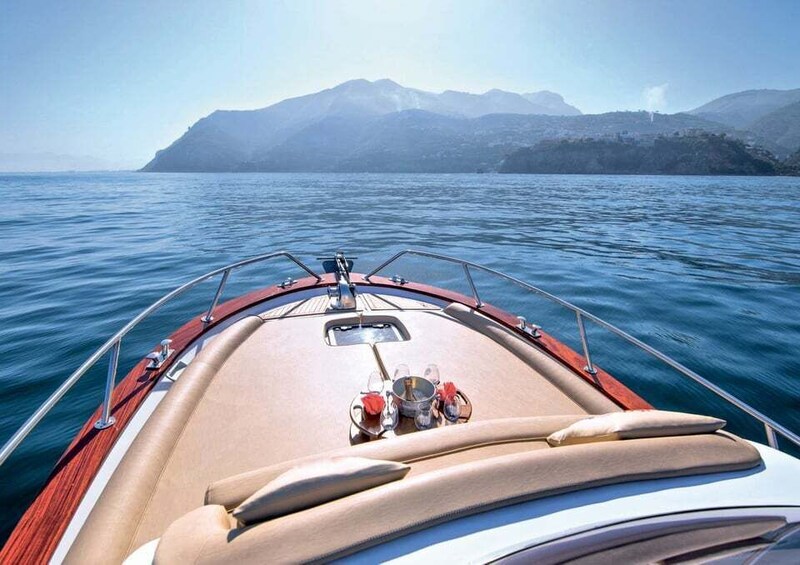 A boat with a dining setup on the deck, surrounded by calm water and distant mountains. 4