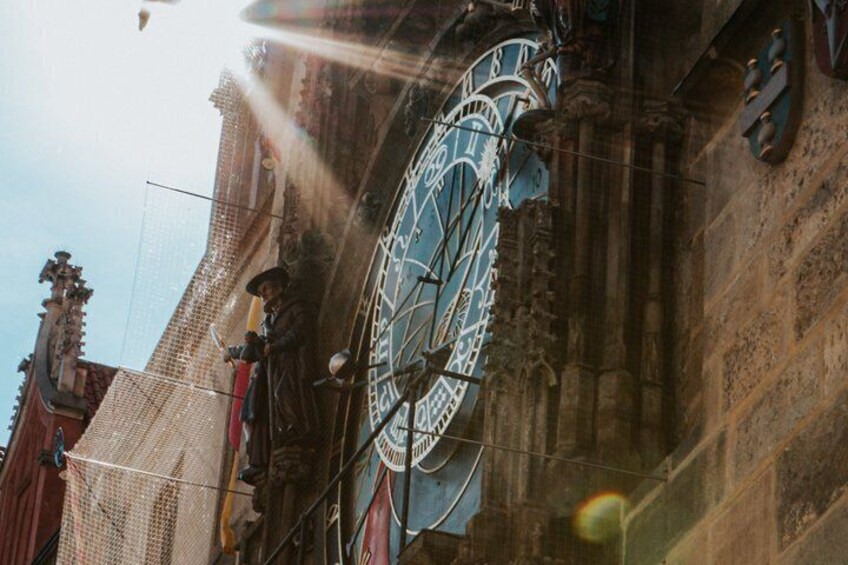 A large clock with Roman numerals on a building facade. 5