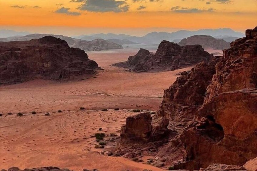 A desert landscape with rocky terrain and distant mountains. 3