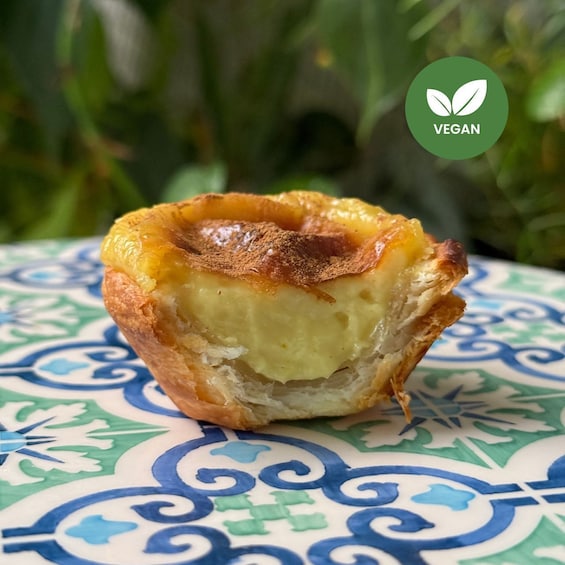 A vegan Portuguese egg tart on a patterned ceramic plate. 1