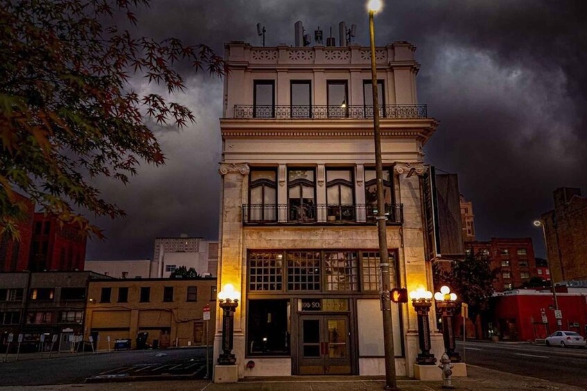 A historic building with ornate architecture, a street lamp, and a dark, cloudy sky. 5