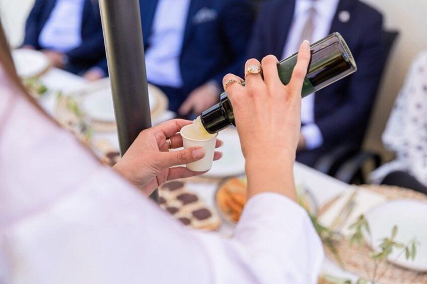 A person pouring a drink from a bottle into a cup. 1