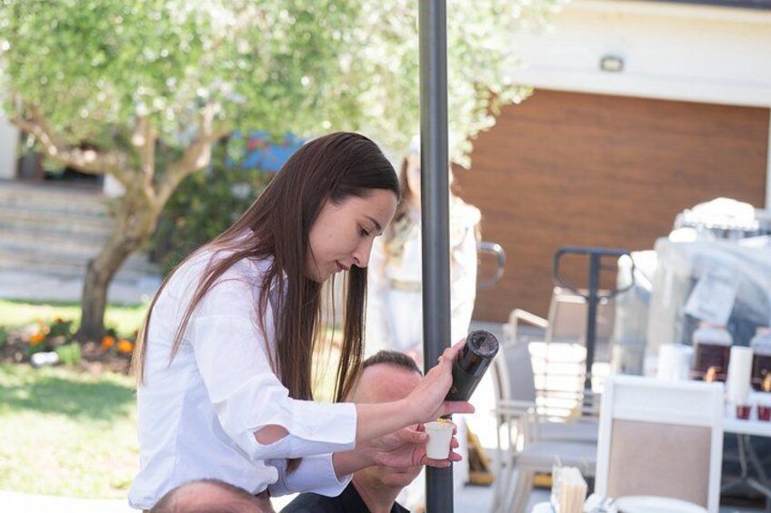 A person using a smartphone outdoors, with a building and trees in the background. 4