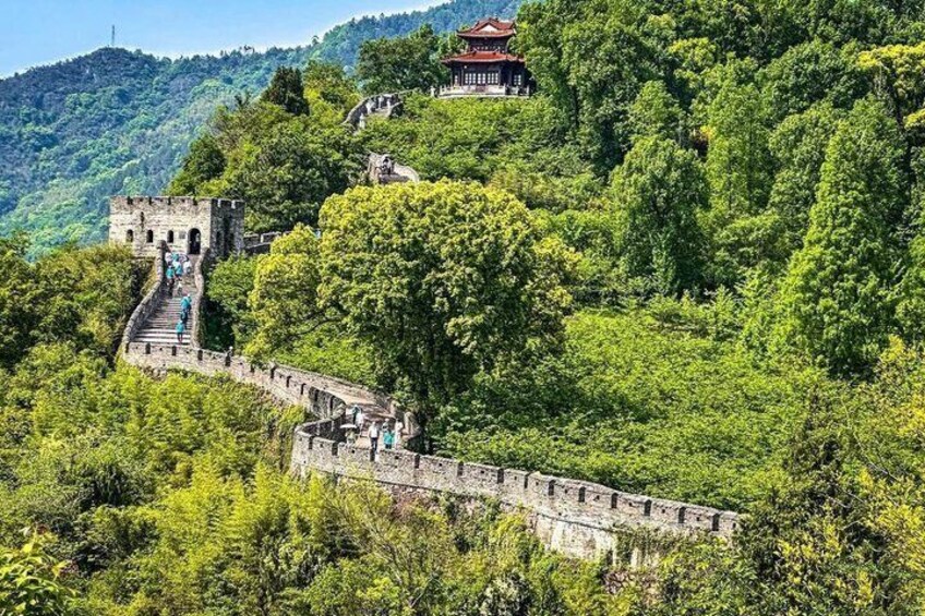 A historic stone wall with a traditional Chinese pavilion on a hillside. 1