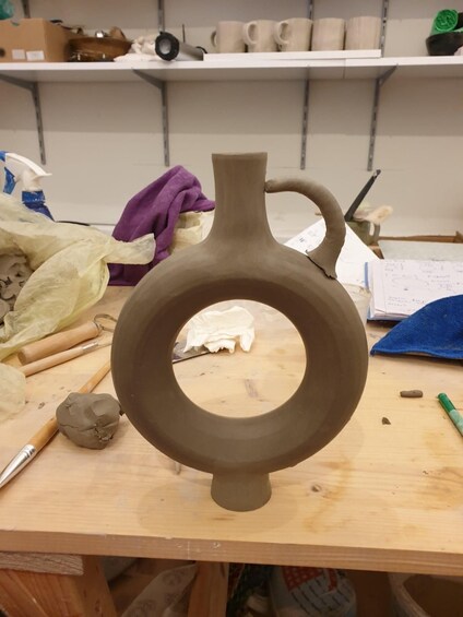 A pottery wheel with a clay vase in progress. 3