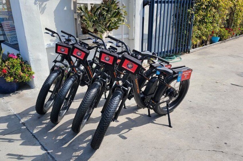 A row of electric scooters parked on a concrete surface. 1