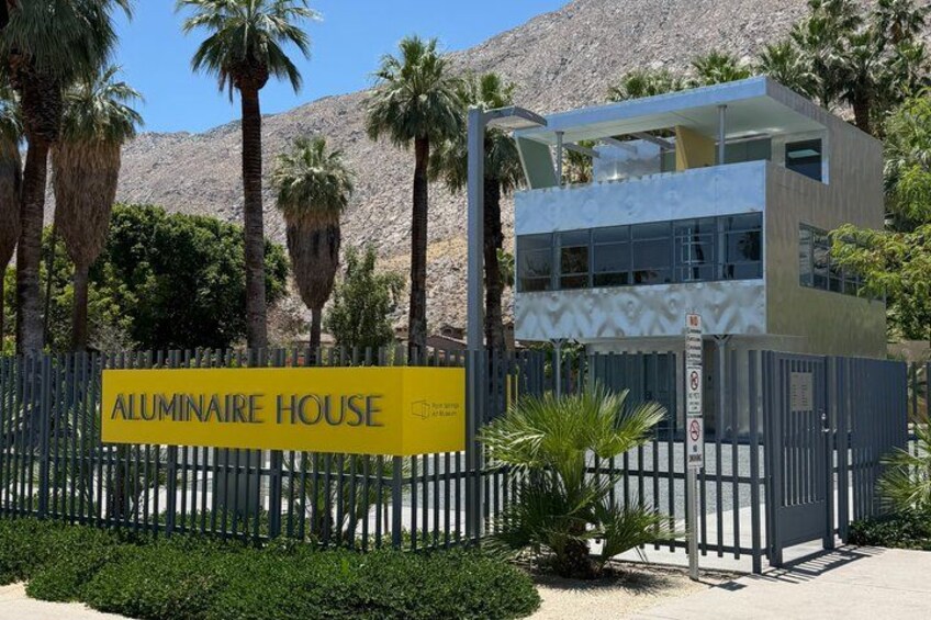 A modern two-story house with a sign reading 'ALUMINAIRE HOUSE.' 3