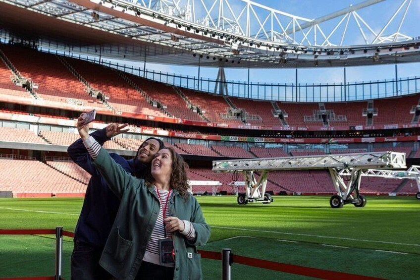 A stadium with empty stands, a person taking a selfie, and a small aircraft on the field. 3