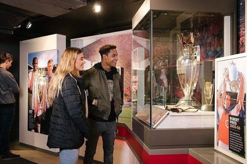 A museum exhibit with a large trophy and posters. 4