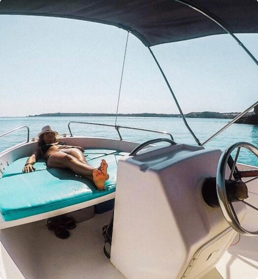 A person lying on a boat with a view of the water and distant land. 2