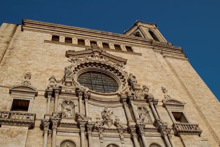A large building with ornate architectural details, including a prominent circular window and statues. 4