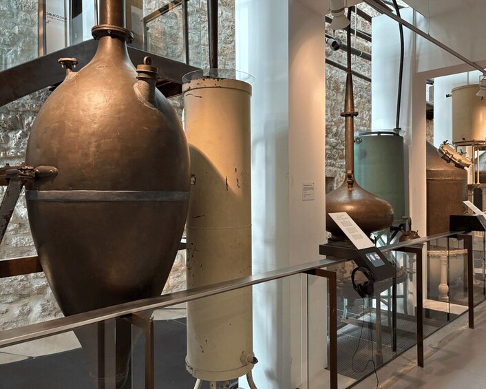 Large industrial kettles and copper stills in a museum setting. 3