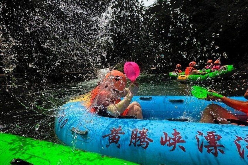 People rafting in a river with water splashing around them. 3
