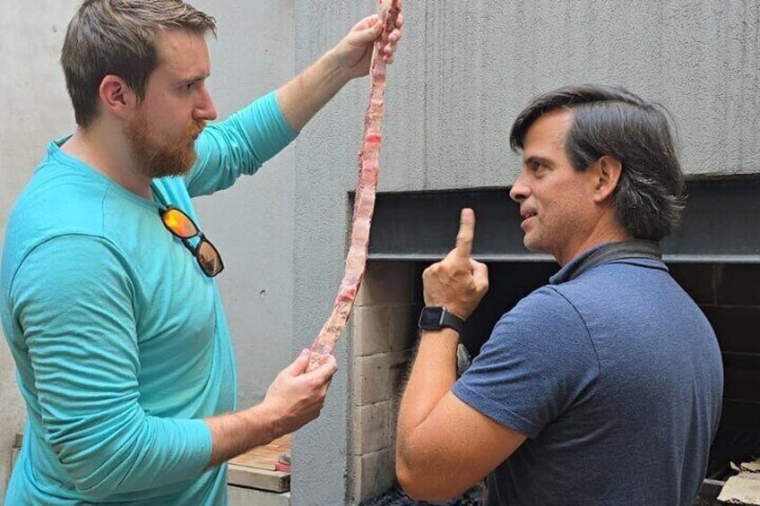 Two people examining a long, thin object. 5