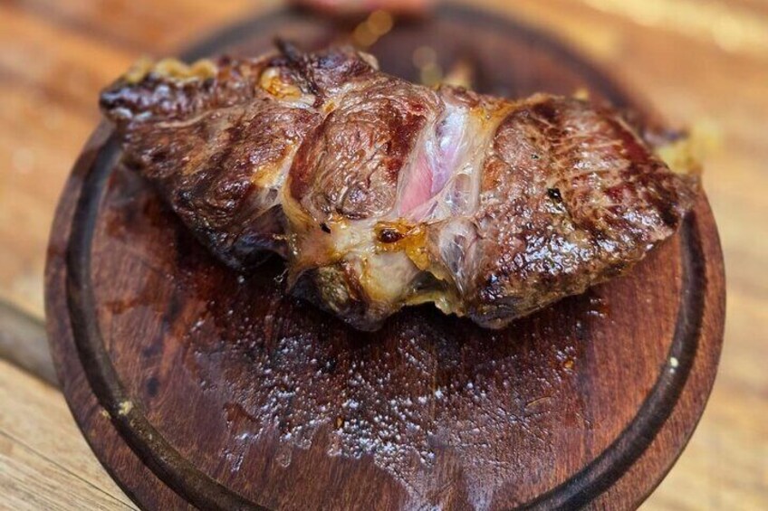 A cooked steak on a wooden plate. 3
