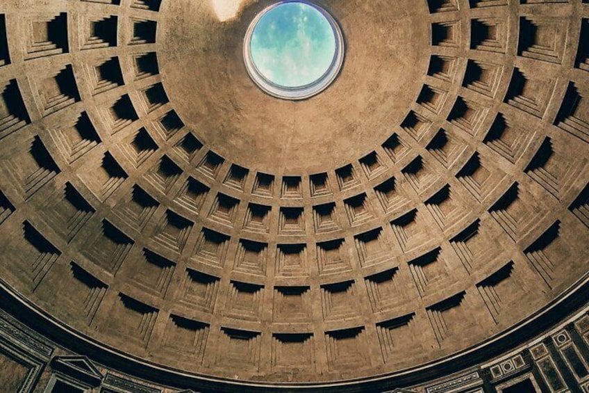 A circular building with a central skylight and a patterned facade. 5