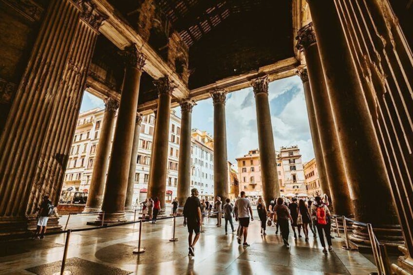 A grand architectural space with large columns and a crowd of people. 3