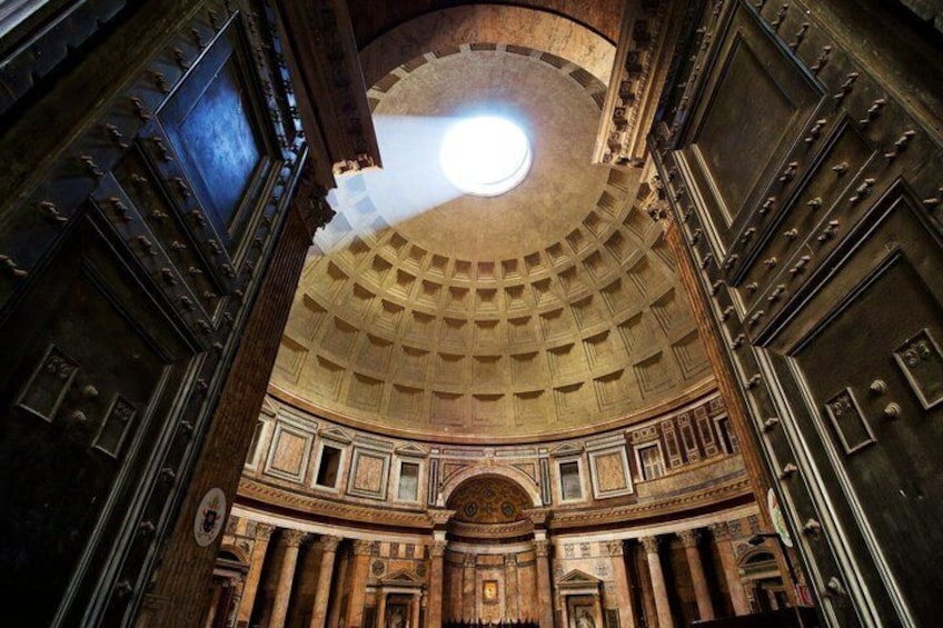 A grand hall with a domed ceiling, ornate columns, and a central chandelier. 1
