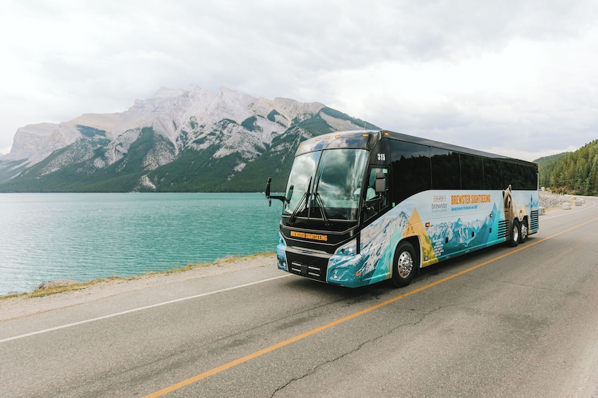 Un autocar de tourisme avec une montagne et un lac en arrière-plan. 3