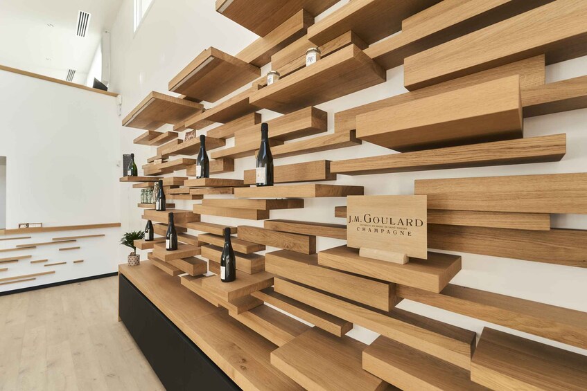 A modern interior with wooden shelves displaying bottles and a sign reading 'J.M. GOUILLARD CHAMPAGNE.' 4