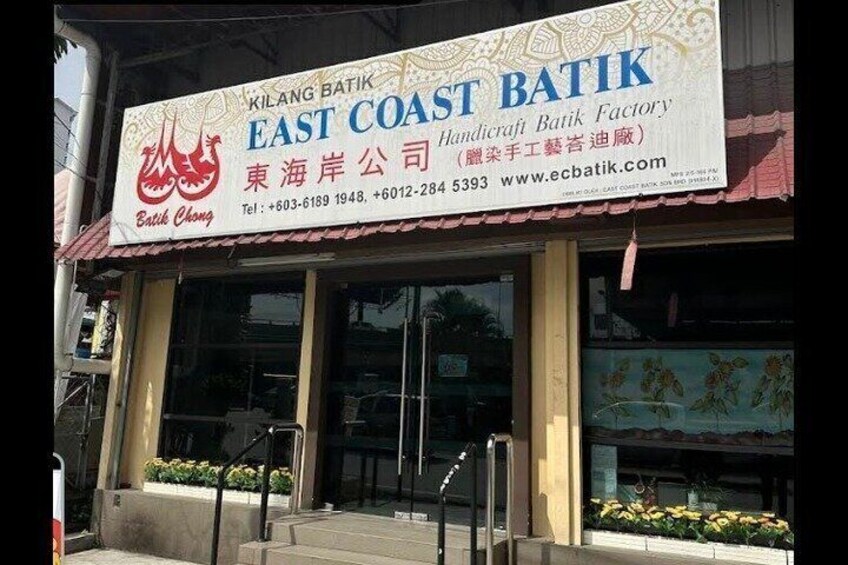 A storefront with a sign for East Coast Batik, including contact information and a website. 2