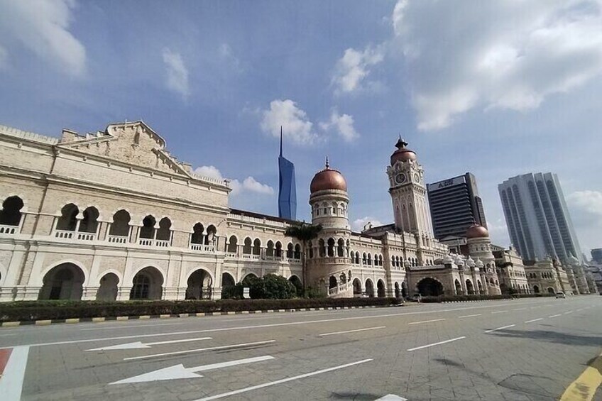 A historic building with domes and arches, a modern skyscraper, and a clear sky. 4