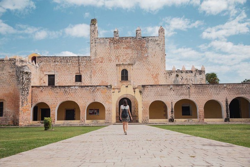 A historical building with arched walkways and a central tower. 5