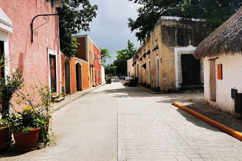 A quiet street lined with historic buildings, a clear sky, and a paved road. 3