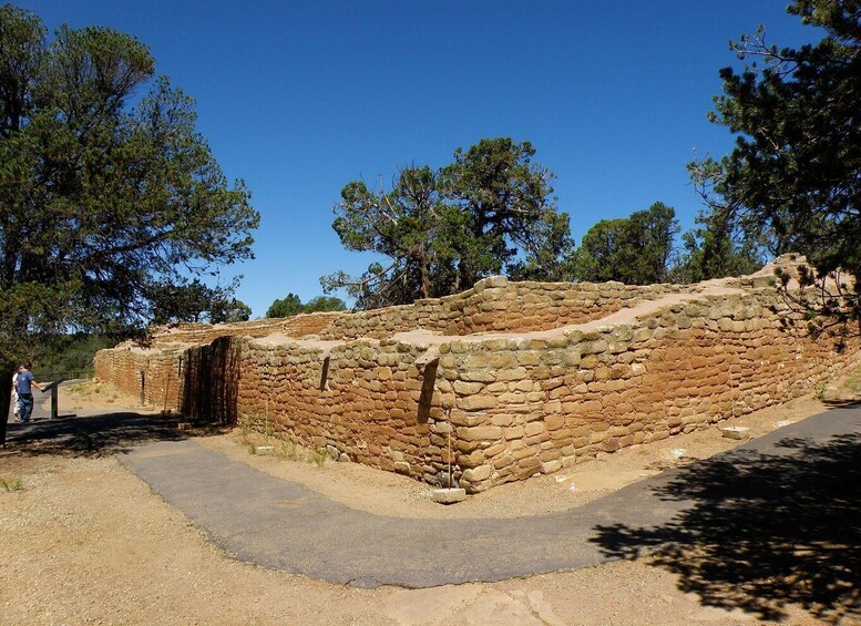 A stone structure with a pathway leading to it, surrounded by trees. 5