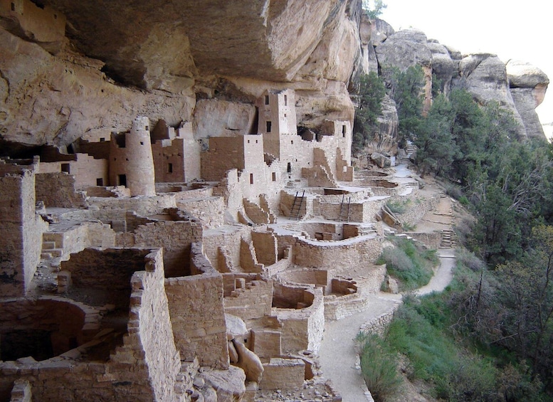 Ancient cliff dwellings with multiple levels and a narrow path leading through the ruins. 1