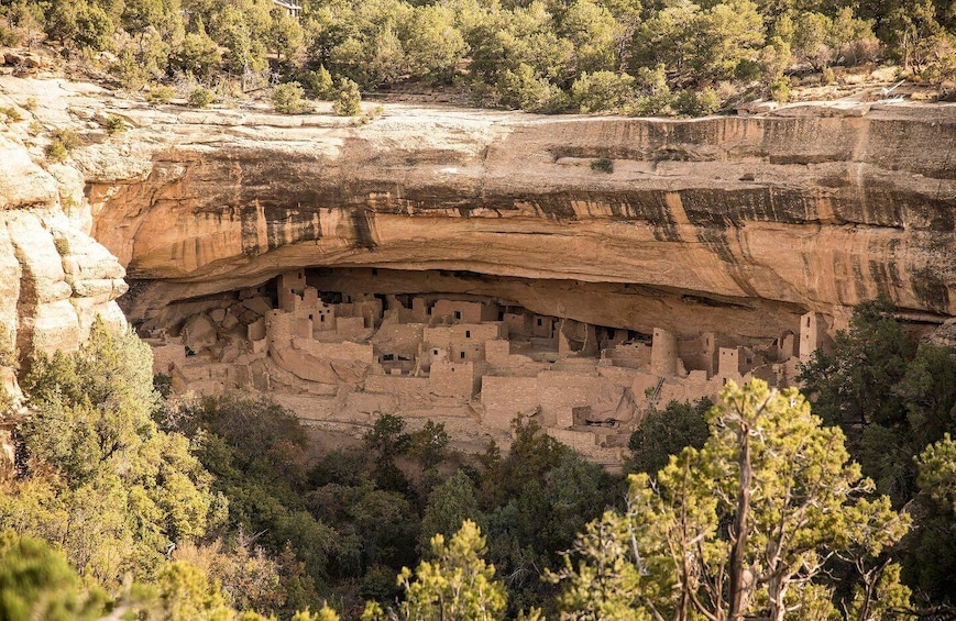 A cliffside with ancient cliff dwellings carved into the rock. 1
