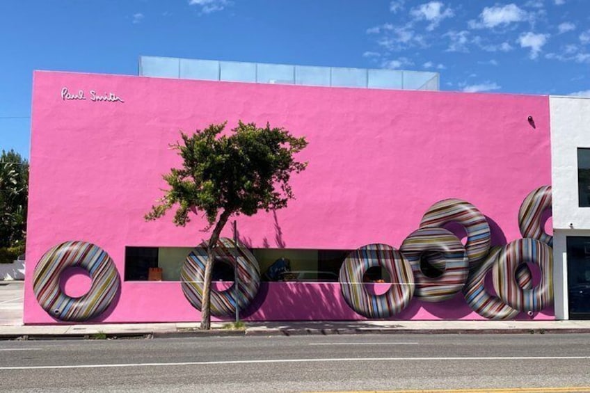 A pink building with a tree and donut-shaped decorations. 1