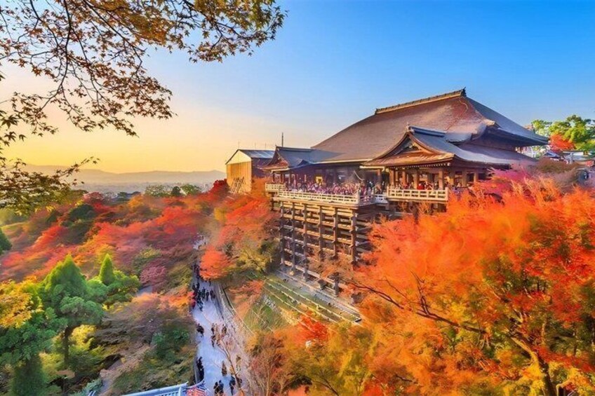 A traditional Japanese building with a wooden structure and a stone base, surrounded by autumn foliage. 5