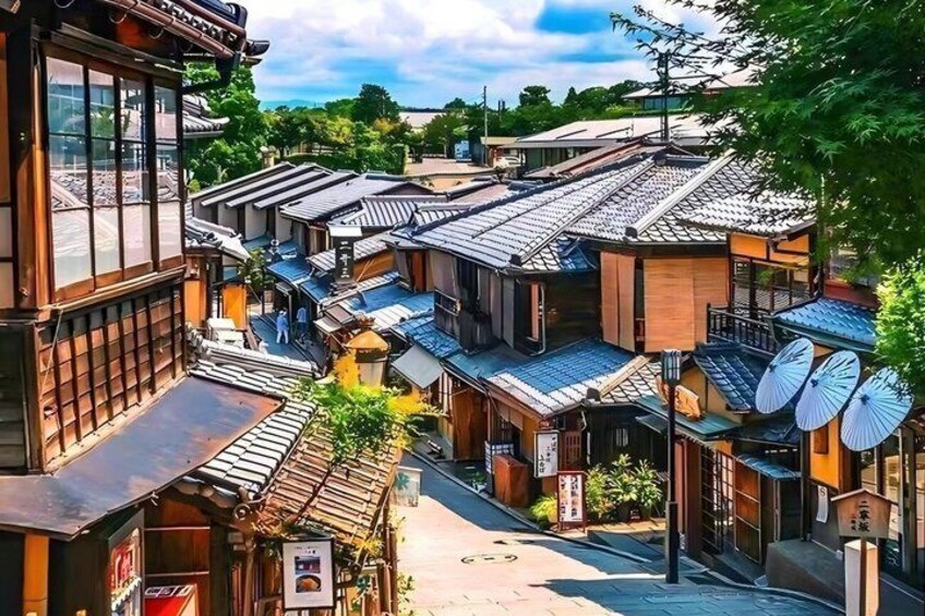 A traditional Japanese street with wooden buildings, tiled roofs, and a clear sky. 4